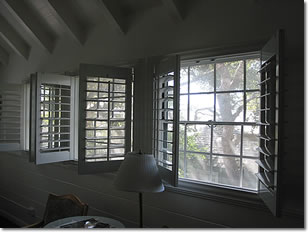 Photograph of the interior of cottage room 203 at the Normandy Inn, looking out of the windows overlooking the oak tree in the courtyard below. Image copyright © Philip W. Tyo 2008