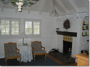 Photograph of the interior of cottage room 203 at the Normandy Inn showing shuttered windows and a gold-tiled fireplace. Image copyright © Philip W. Tyo 2008