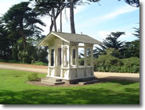 A photograph of a small wooden structure used as a resting place in Sutro Heights Park in San Francisco, California.  Image copyright © Philip W. Tyo 2007